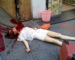 Chinese woman lies in a pool of blood on the sidewalk