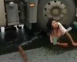 Woman wedged under wheel of a truck