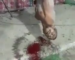 Beaten man hanging by his feet