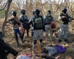 Cartel members hold severed human heads