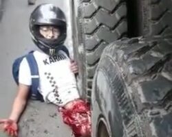 Motorcyclist with half of his body crushed by truck is still alive