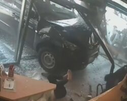 Female café customer pinned by vehicle
