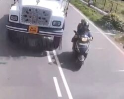 Woman falls from motorcycle directly under truck