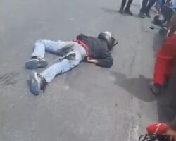 Collision with parked car sends motorcyclist under truck