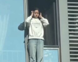 Young woman jumps backwards from tall building