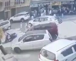 Old man sitting on road run over by SUV