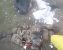 Soldier sticks Ukrainian flag into body of fallen Russian