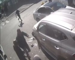 Woman pinned against wall by car