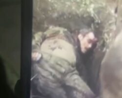Ukrainian soldiers handle dead body of their enemy