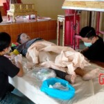 Preparing dead body of woman for burial