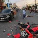 Two men on moped collide head-on with car