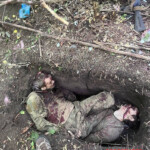 Burying two fallen Russian soldiers in shallow grave