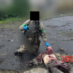Ukrainian soldier poses with decapitated enemy